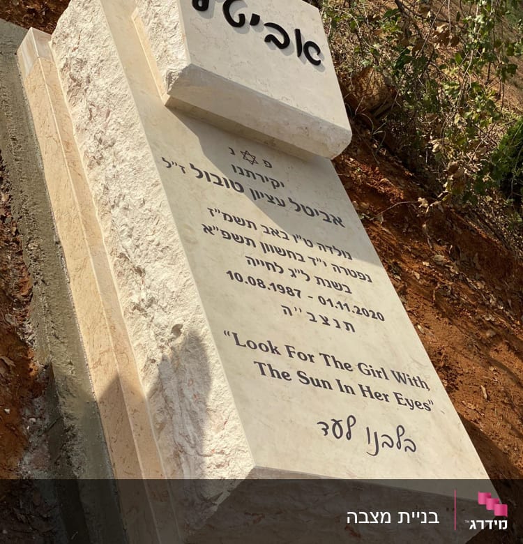 מצבה עם כיתוב בעברית ואנגלית ביער